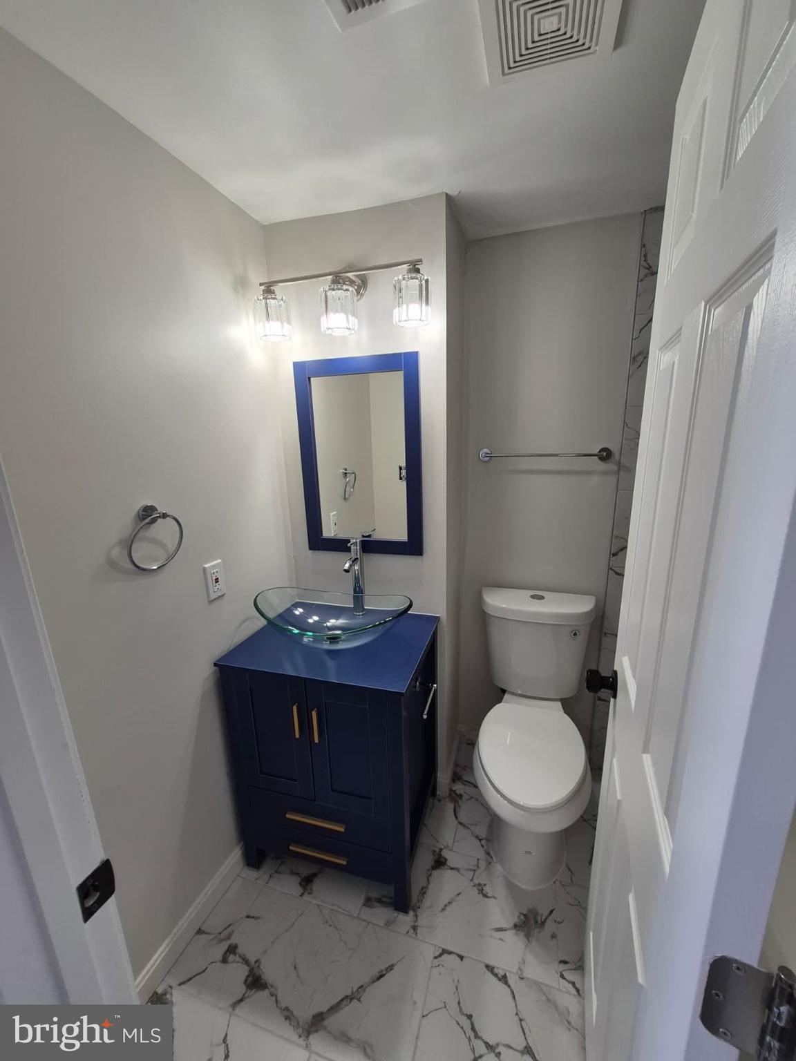 2015 East Fairmount Avenue Baltimore, MD 21231 - Photo 23 of 27 a bathroom with a toilet a sink and mirror