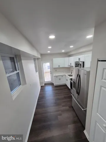 a view of a refrigerator in kitchen and wooden floor