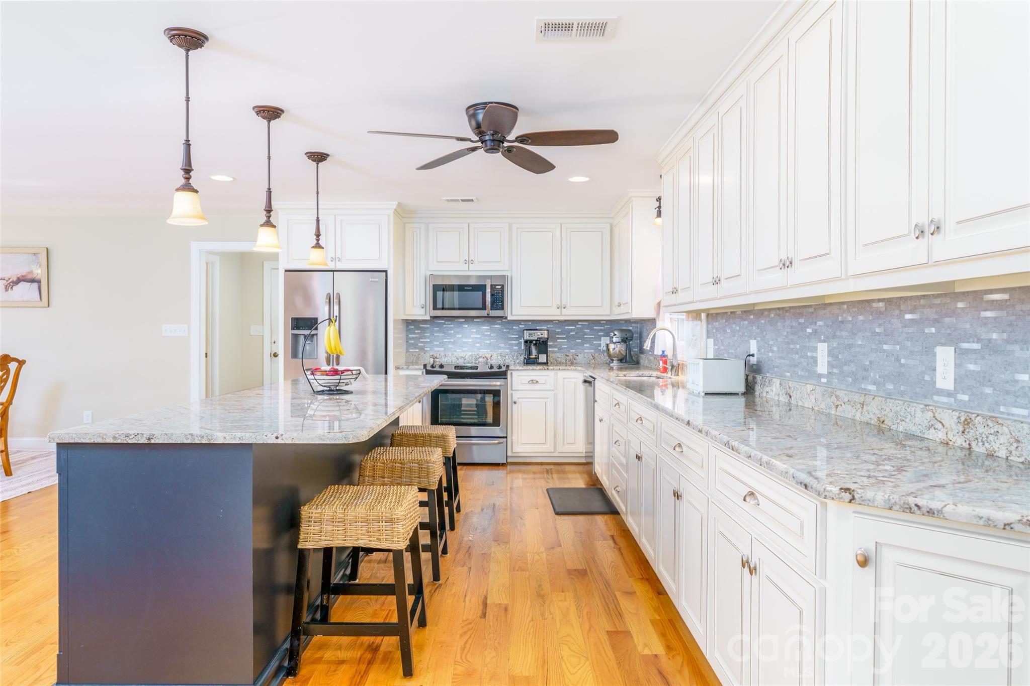 8194 Mallard Road Denver, NC 28037 - Photo 5 of 48 a kitchen with kitchen island granite countertop a sink a counter space appliances and cabinets
