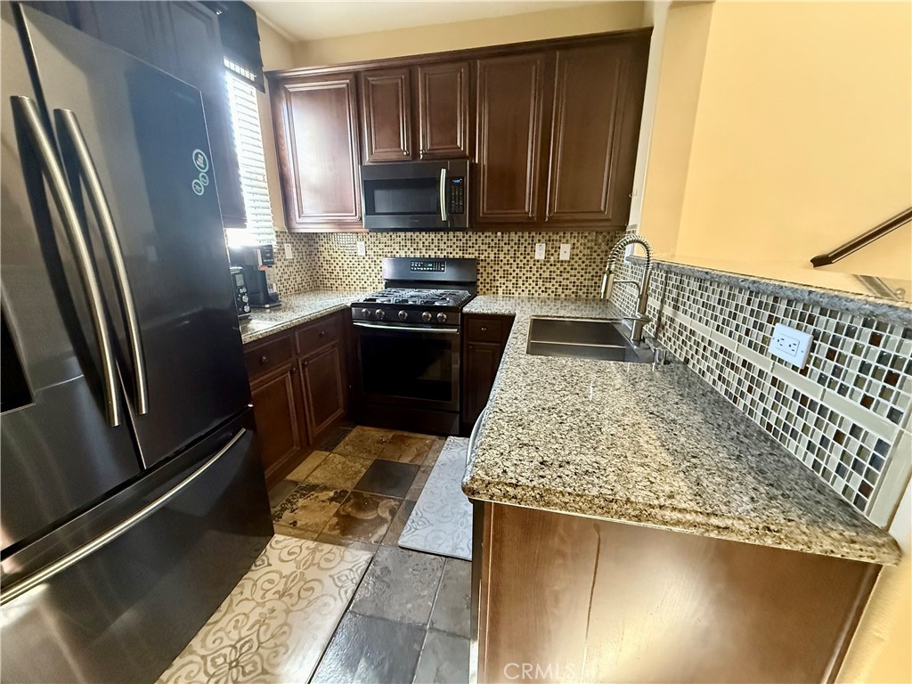 44965 Blue Rosemary Way Temecula, CA 92592 - Photo 16 of 25 a kitchen with granite countertop stainless steel appliances and wooden cabinets