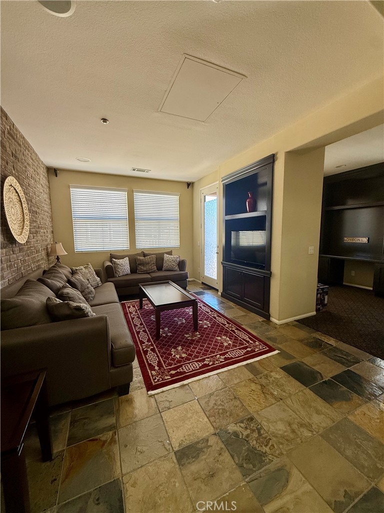 44965 Blue Rosemary Way Temecula, CA 92592 - Photo 6 of 25 a living room with furniture a flat screen tv and a window
