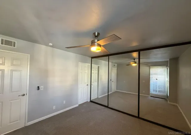an empty room with fan and shower