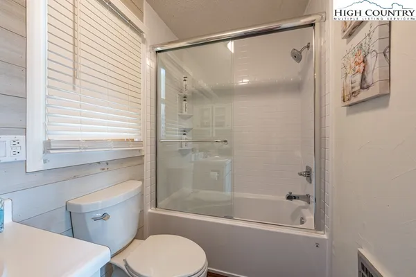 a bathroom with a shower a toilet and a sink