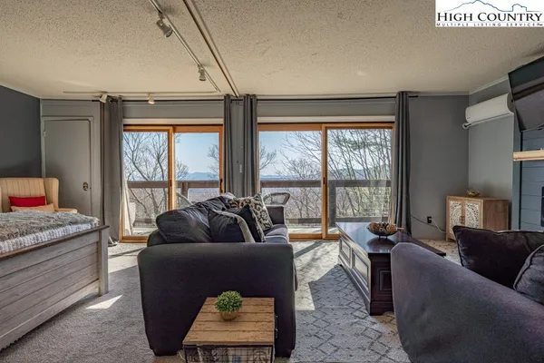 a living room with furniture and a floor to ceiling window