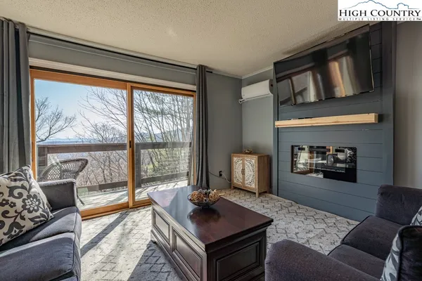 a living room with furniture and a floor to ceiling window