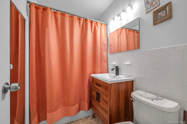 a bathroom with a sink a toilet and a mirror