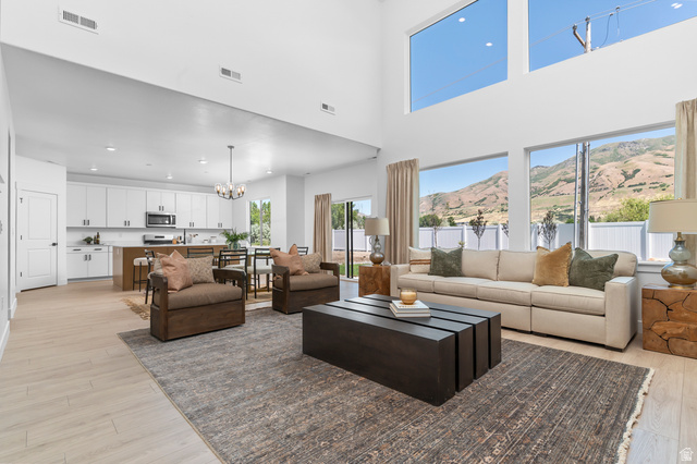 1352 West 2350 South, Unit 18 Perry, UT 84302 - Photo 4 of 26 Open-concept living space featuring high ceilings, light wood-finish flooring, and expansive windows
