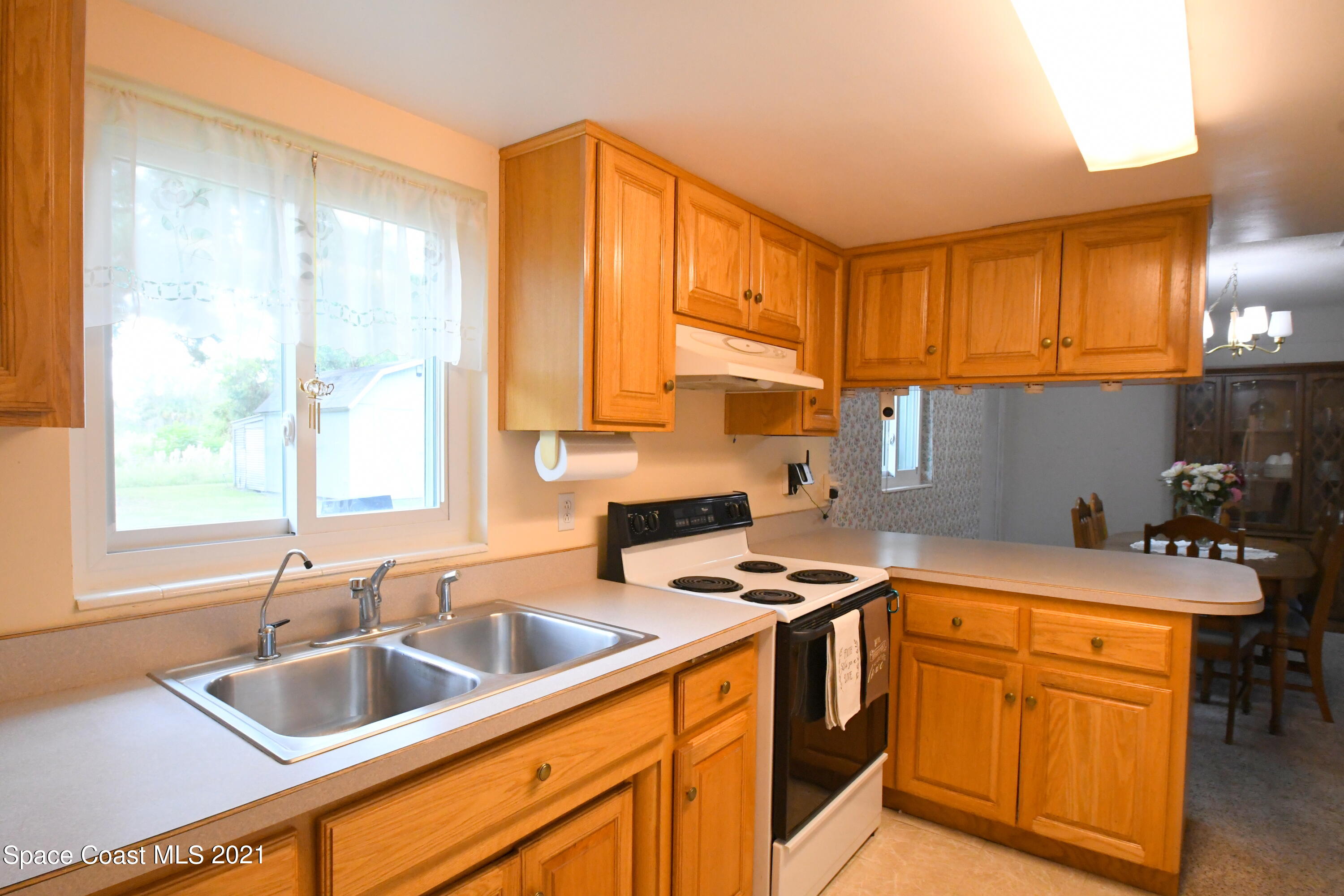 1871 Pinewood Road Melbourne, FL 32934 - Photo 11 of 22 a kitchen with stainless steel appliances granite countertop a sink stove and cabinets