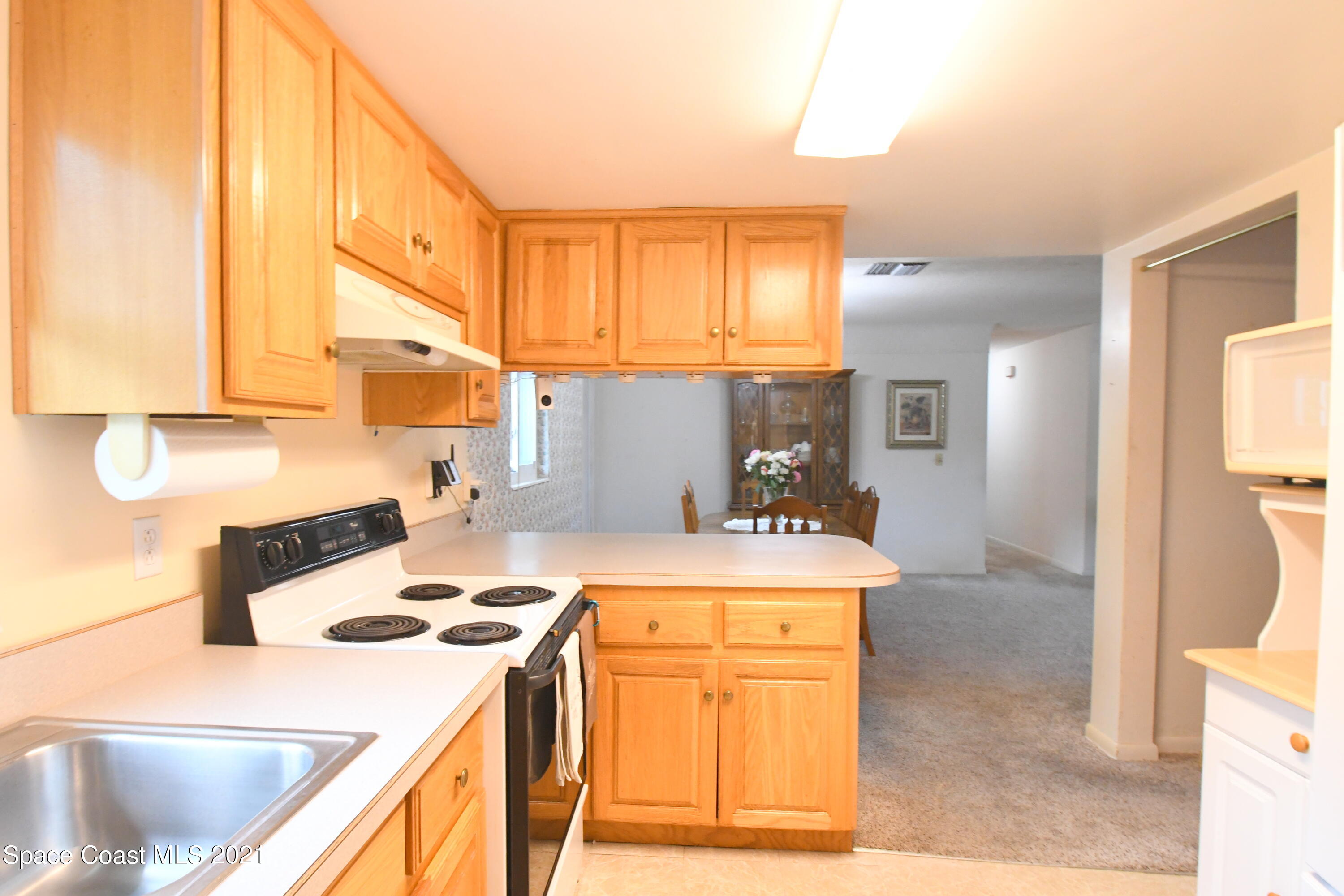 1871 Pinewood Road Melbourne, FL 32934 - Photo 12 of 22 a kitchen with a stove a sink and a refrigerator