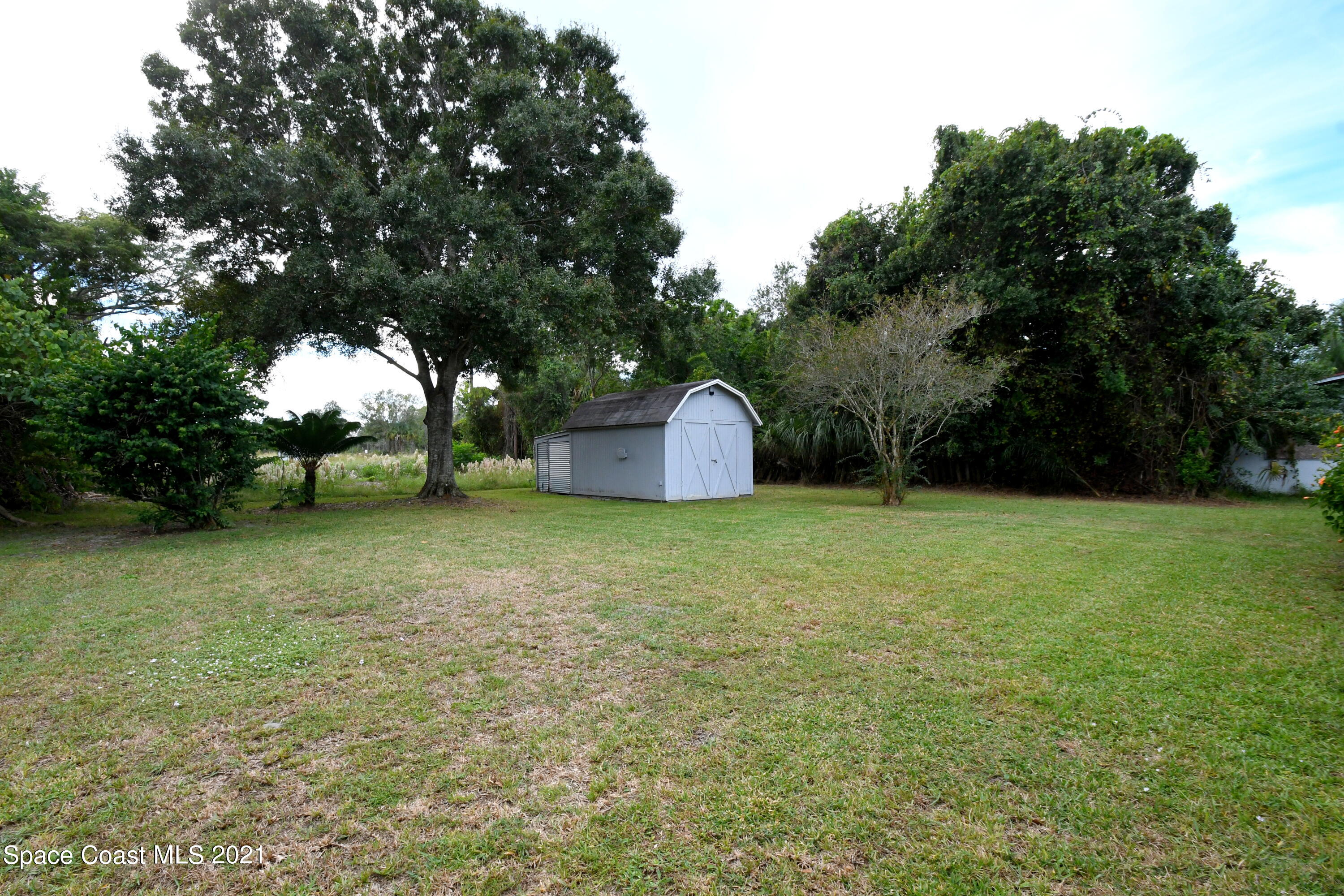 1871 Pinewood Road Melbourne, FL 32934 - Photo 20 of 22 a backyard of a house with lots of green space