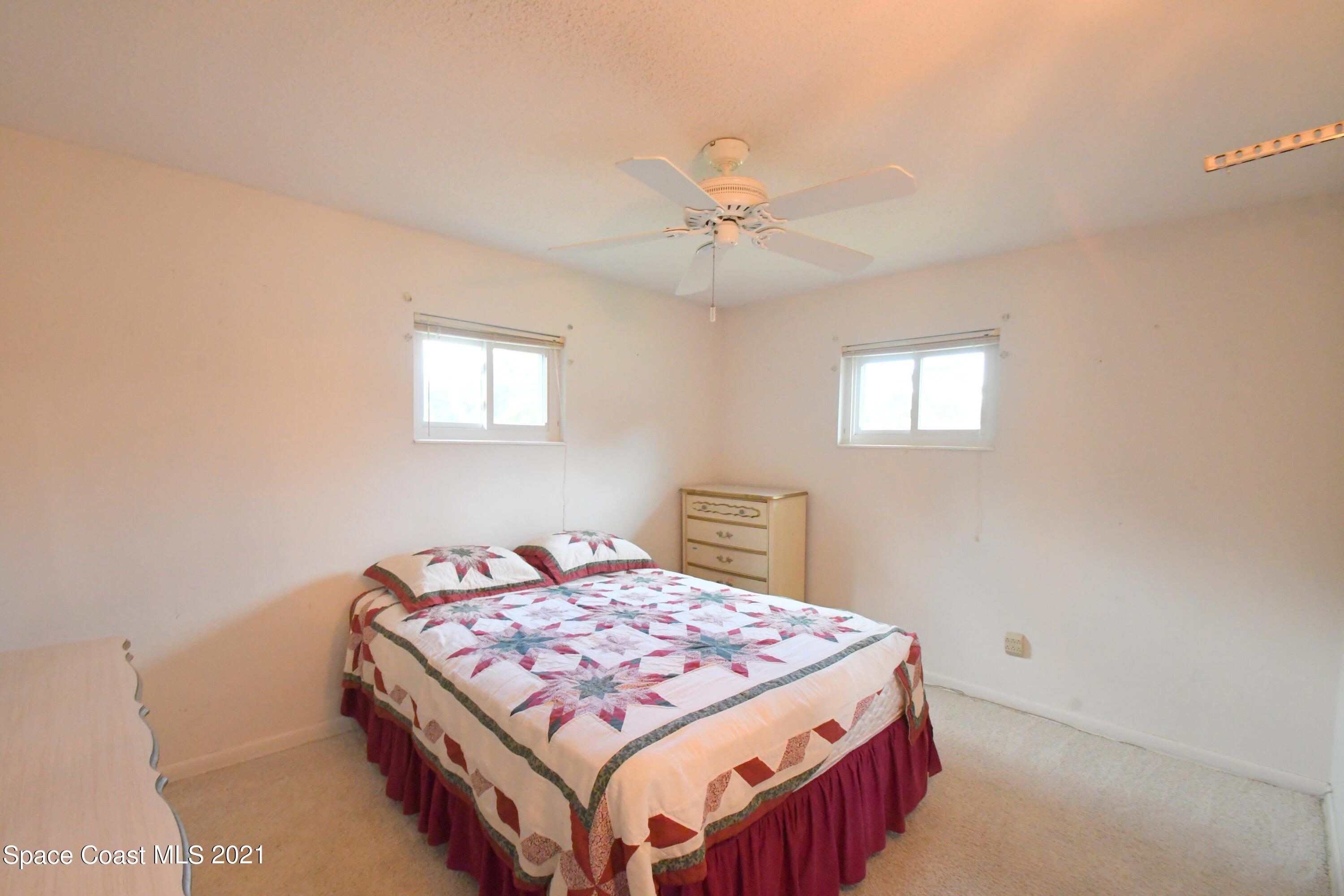 1871 Pinewood Road Melbourne, FL 32934 - Photo 7 of 22 a bedroom with a bed a chandelier and a window