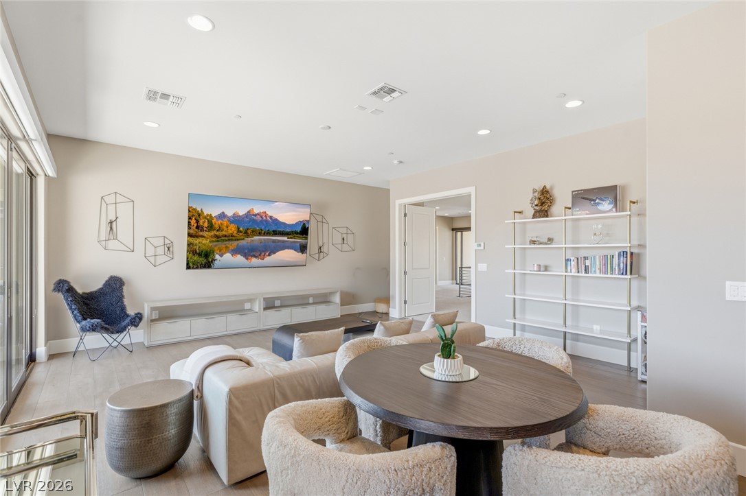 5 Crystal Tree Pass Henderson, NV 89052 - Photo 28 of 67 Natural light illuminates a refined living area with light-colored flooring and a television display.