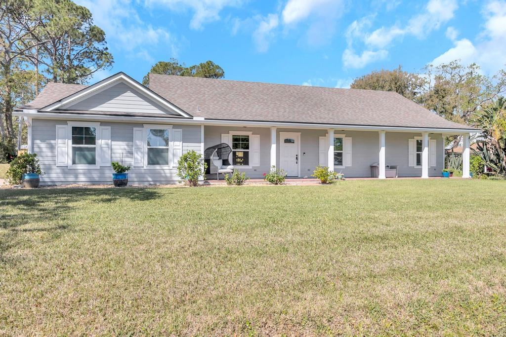105 Rutgers Road St. Augustine, FL 32086 - Photo 3 of 34 a front view of a house with large trees and plants