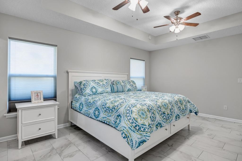 105 Rutgers Road St. Augustine, FL 32086 - Photo 34 of 34 a bedroom with a bed chandelier dresser and a window
