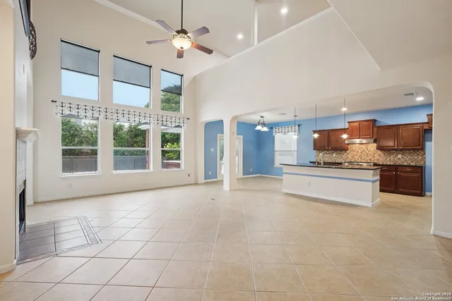 a large kitchen with kitchen island granite countertop a stove a sink a counter space and stainless steel appliances