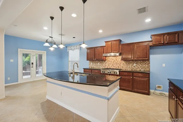 a kitchen with kitchen island a large counter top appliances and cabinets