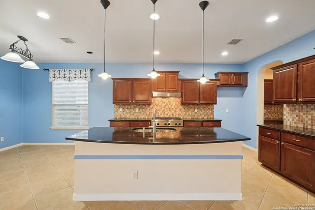 a kitchen with stainless steel appliances granite countertop a sink a stove and a refrigerator
