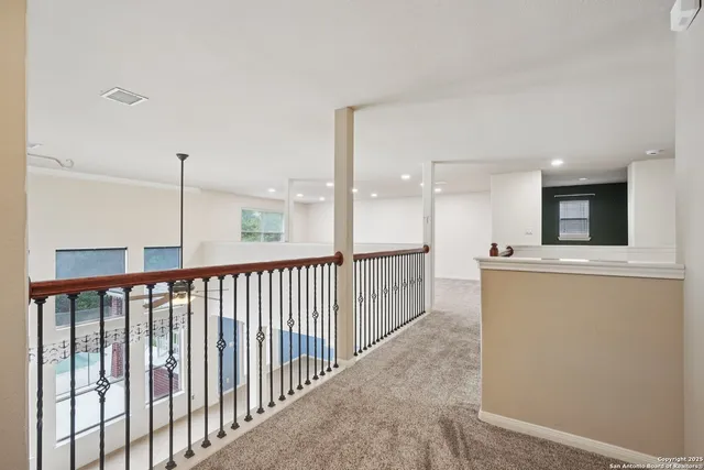 a view of an empty room and chandelier fan