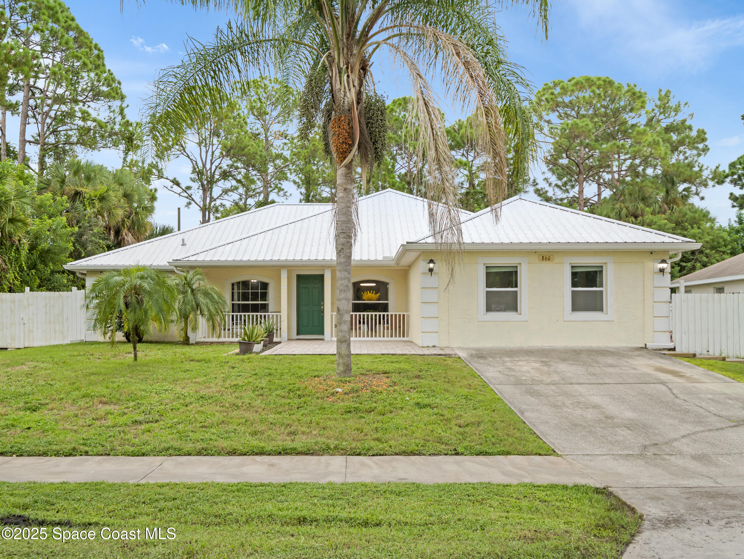 860 Tupelo Road Southwest Palm Bay, FL 32908 - Photo 1 of 26 a front view of a house with a yard
