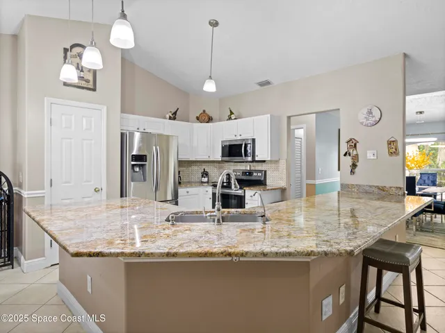 a kitchen with stainless steel appliances granite countertop a kitchen island a stove and a sink