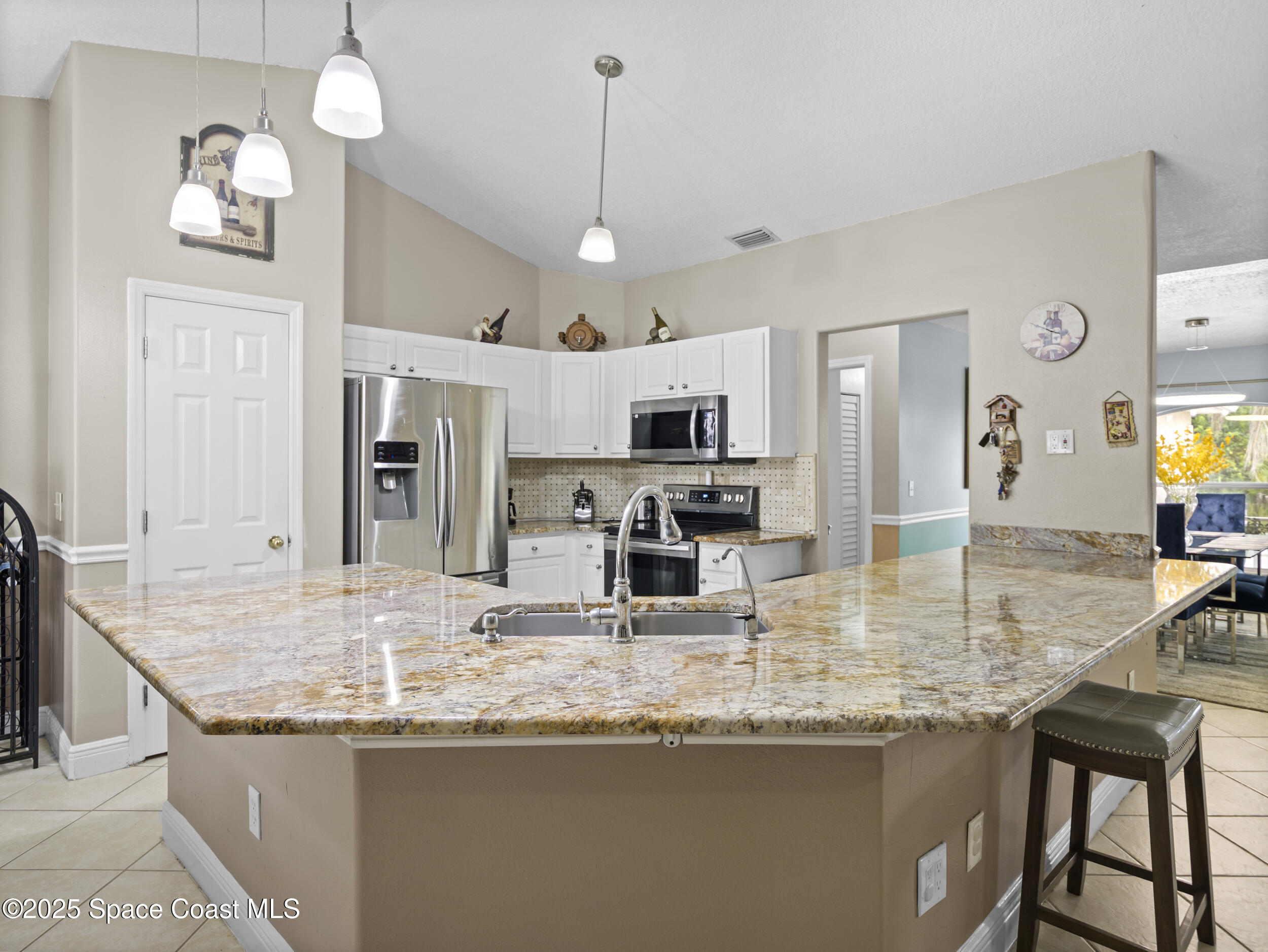860 Tupelo Road Southwest Palm Bay, FL 32908 - Photo 15 of 26 a kitchen with stainless steel appliances granite countertop a kitchen island a stove and a sink