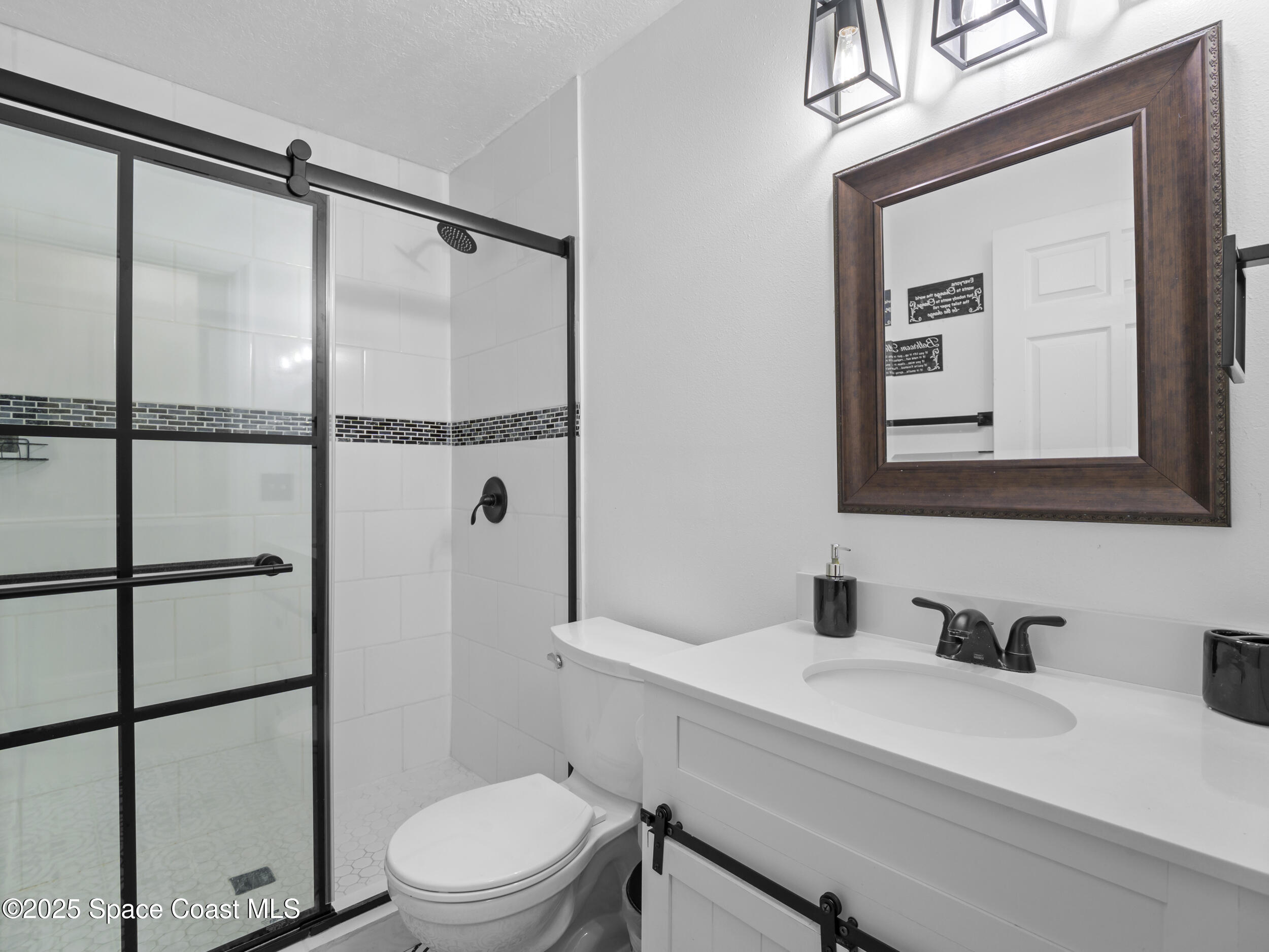 860 Tupelo Road Southwest Palm Bay, FL 32908 - Photo 18 of 26 a bathroom with a sink a toilet and shower