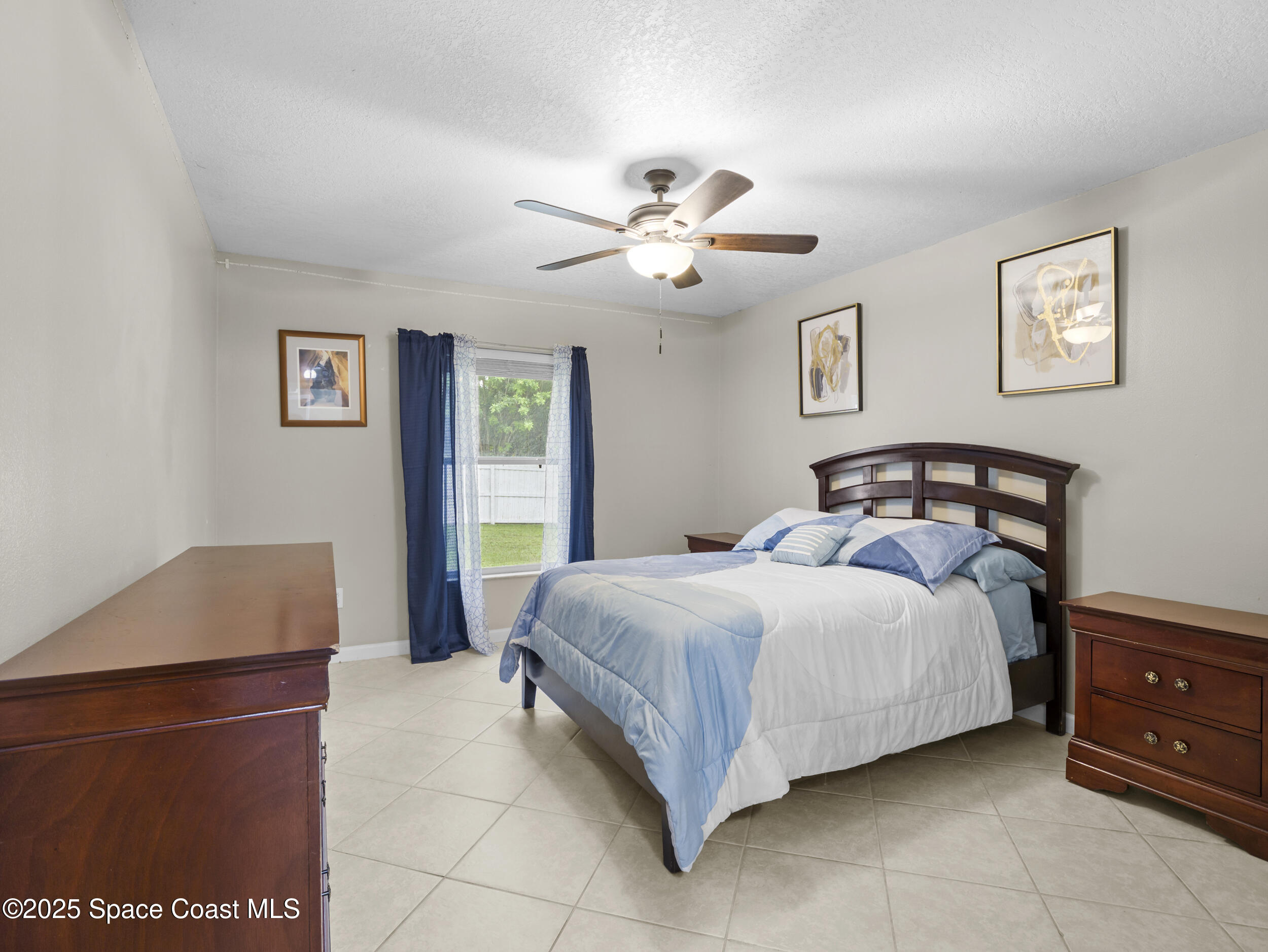 860 Tupelo Road Southwest Palm Bay, FL 32908 - Photo 19 of 26 a bedroom with a bed and a chandelier