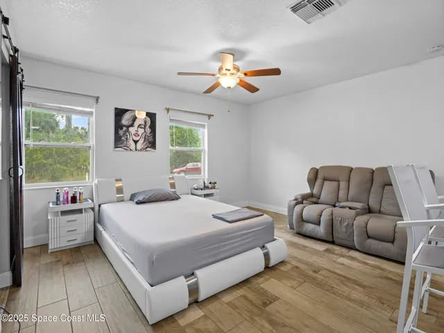 a bedroom with a large bed and a chandelier