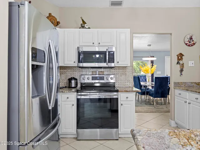 a kitchen with stainless steel appliances granite countertop a stove refrigerator and a microwave