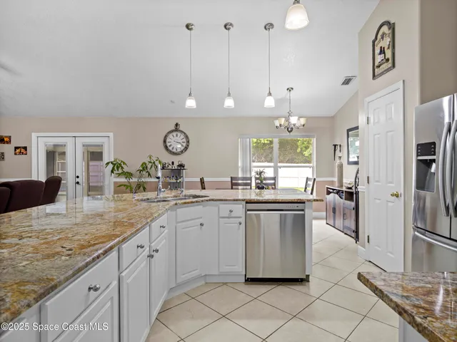 a large kitchen with kitchen island granite countertop a large counter top and stainless steel appliances