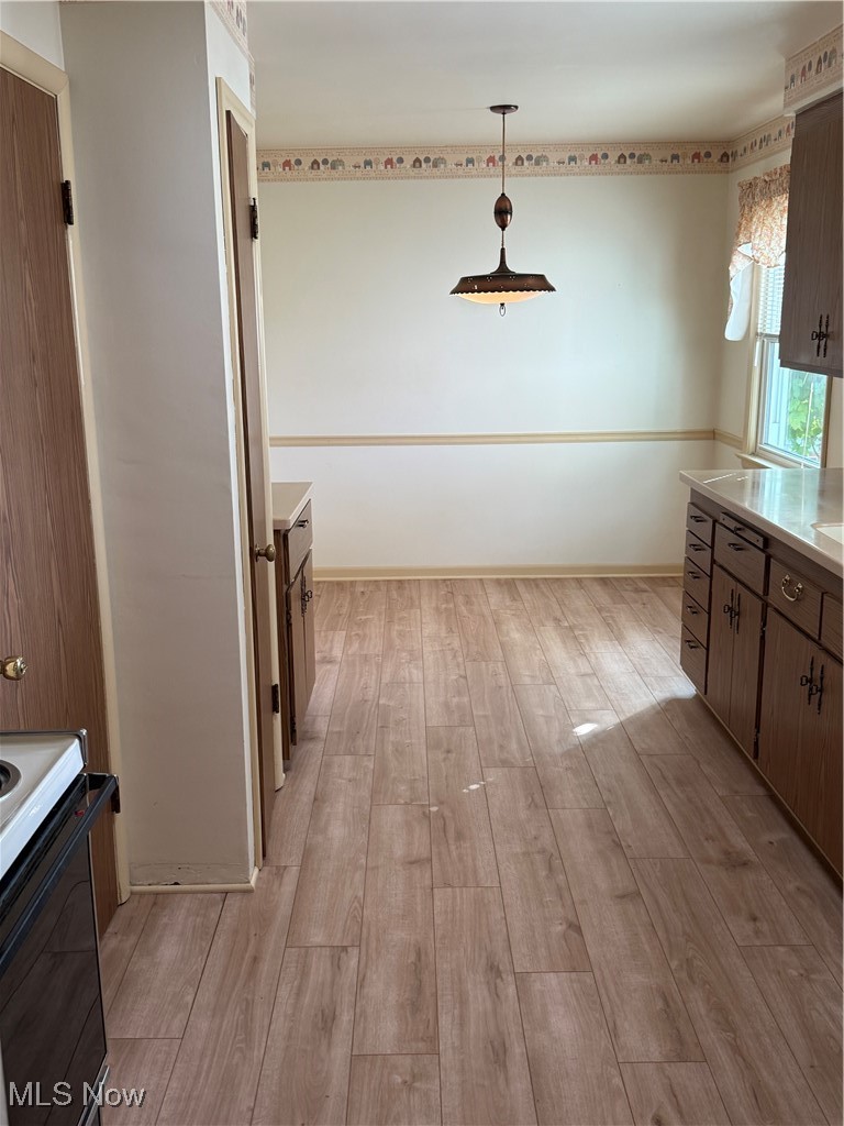 1284 Haverston Road Lyndhurst, OH 44124 - Photo 20 of 43 Kitchen featuring range, light wood finished floors, light countertops, decorative light fixtures, and brown cabinets