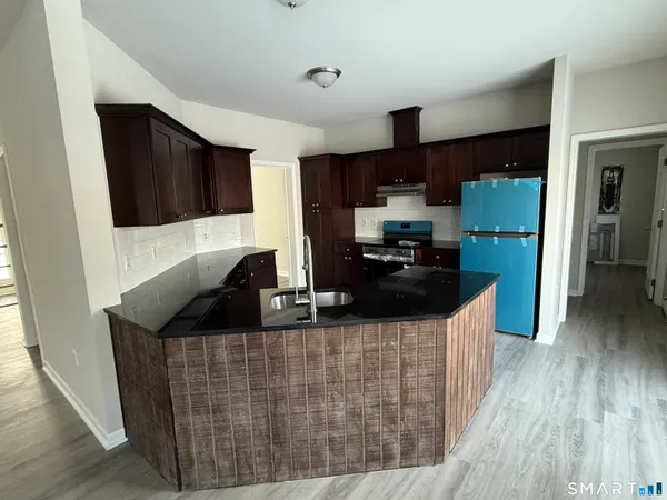 a kitchen with stainless steel appliances granite countertop a sink stove and refrigerator