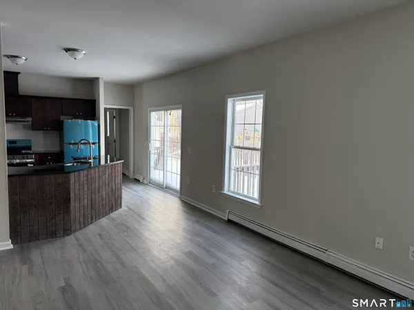 a large kitchen with wooden floor and a window
