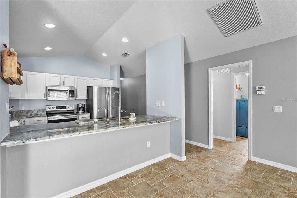 15105 Gulistan Avenue Port Charlotte, FL 33953 - Photo 15 of 39 a large kitchen with stainless steel appliances a stove a sink and a refrigerator