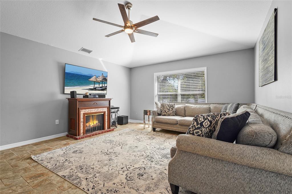 15105 Gulistan Avenue Port Charlotte, FL 33953 - Photo 16 of 39 a living room with furniture a window and a fireplace