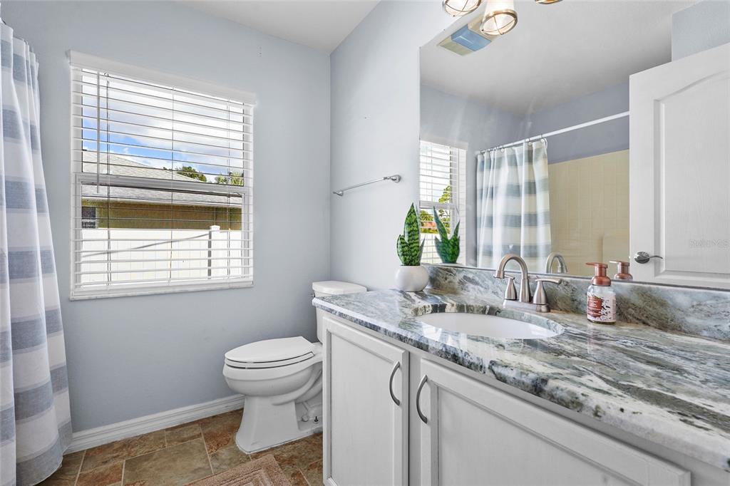 15105 Gulistan Avenue Port Charlotte, FL 33953 - Photo 22 of 39 a bathroom with a granite countertop sink toilet and mirror