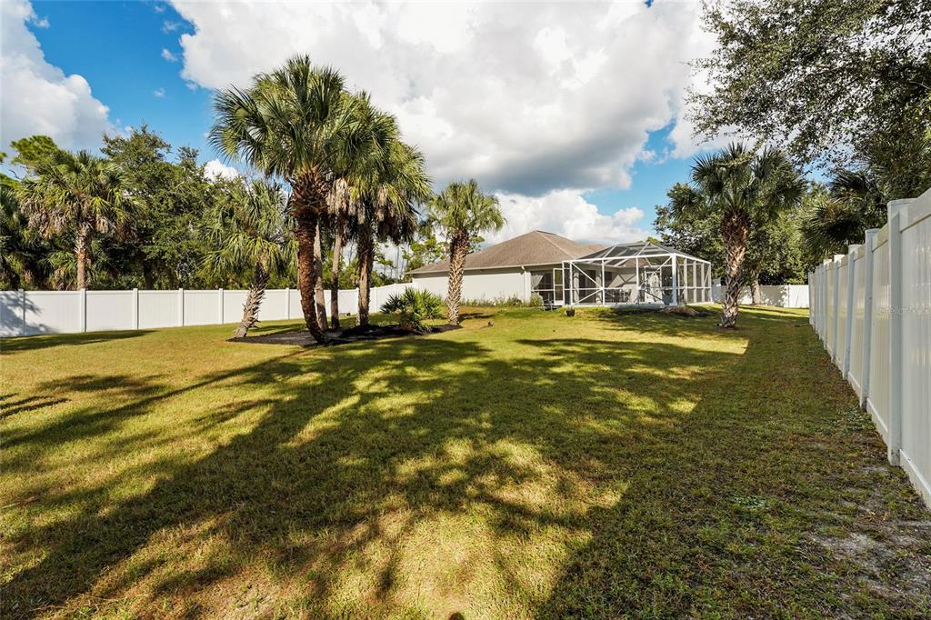 15105 Gulistan Avenue Port Charlotte, FL 33953 - Photo 33 of 39 a view of a swimming pool with a yard and palm trees