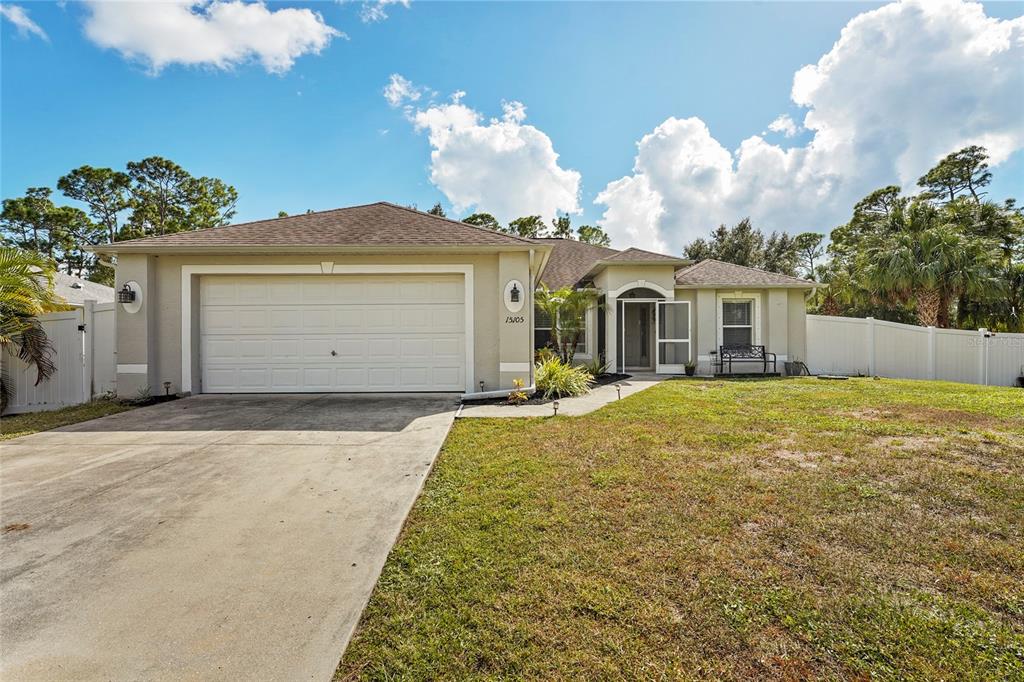 15105 Gulistan Avenue Port Charlotte, FL 33953 - Photo 6 of 39 a front view of a house with a yard and garage