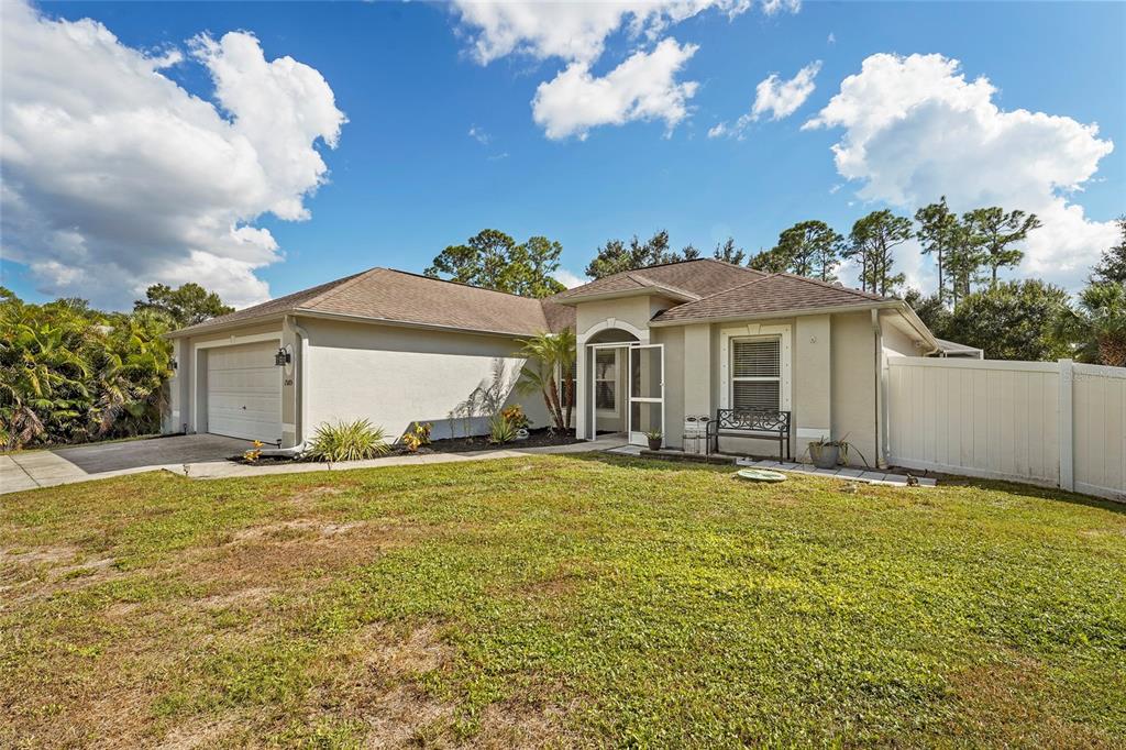15105 Gulistan Avenue Port Charlotte, FL 33953 - Photo 7 of 39 a view of a house with a yard and garage