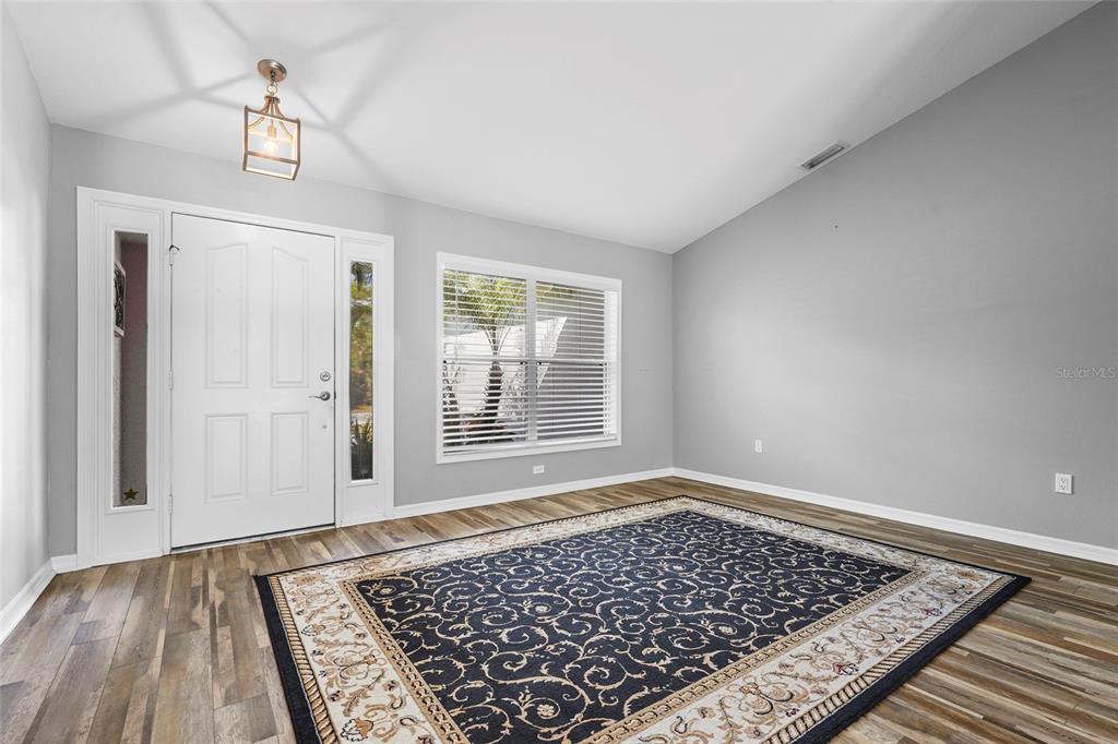 15105 Gulistan Avenue Port Charlotte, FL 33953 - Photo 10 of 39 wooden floor in an empty room with a window