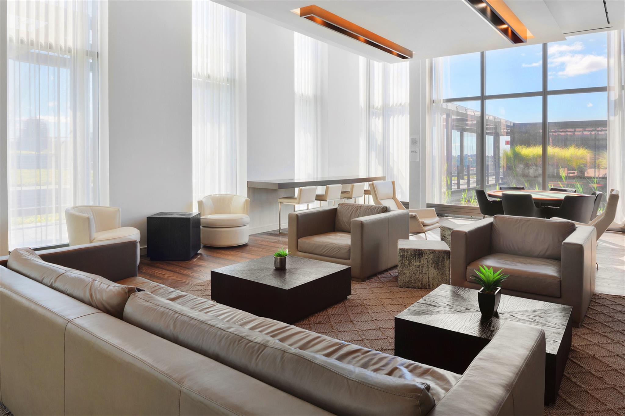 131-01 40 Road, Unit 11M Queens, NY 11354 - Photo 11 of 12 a living room with furniture and large windows