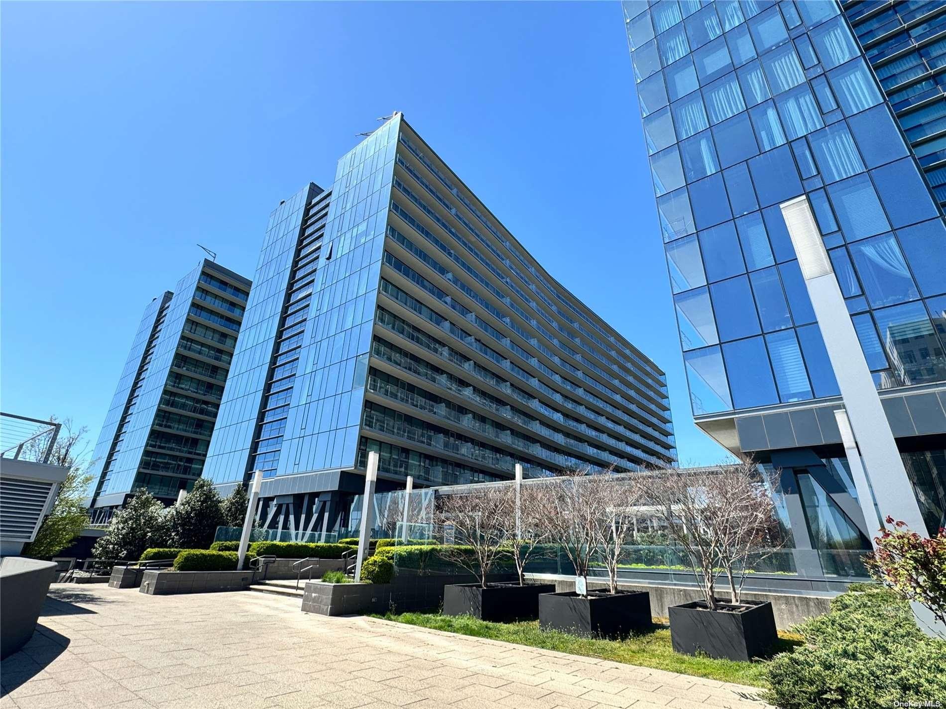 131-01 40 Road, Unit 11M Queens, NY 11354 - Photo 12 of 12 a view of a patio with a table and chairs under an umbrella with a barbeque
