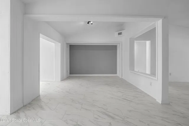 a bedroom with a bed a dresser and next to a window