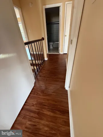 a view of a hallway with wooden floor and staircase