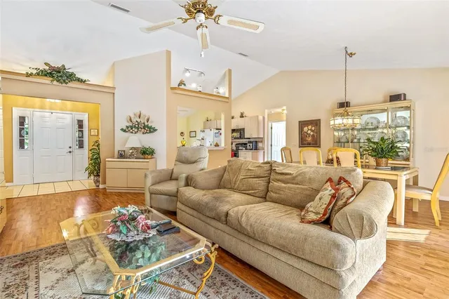 a living room with furniture kitchen view and large windows