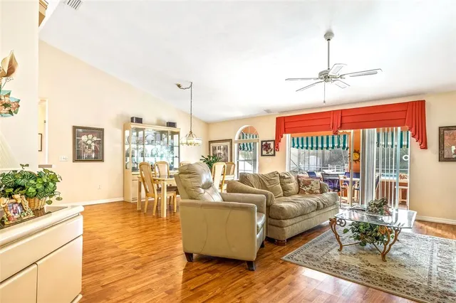 a living room with furniture a chandelier and a floor to ceiling window