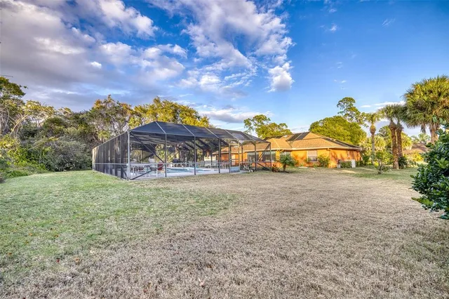 a view of a big house with a big yard and large trees