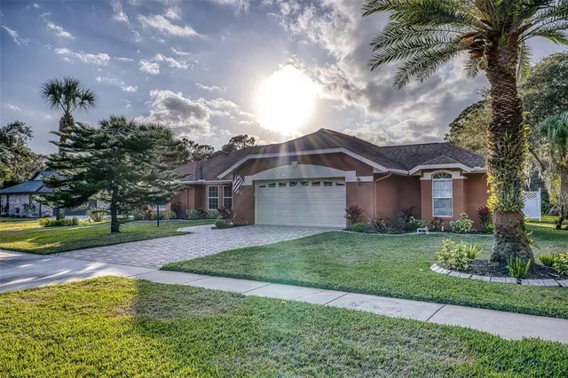 a front view of a house with a garden and trees