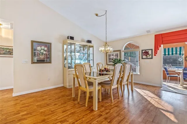 a dining room with furniture a chandelier and wooden floor