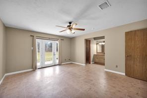 10235 White Rock Road Conroe, TX 77306 - Photo 11 of 25 an empty room with chandelier fan and windows